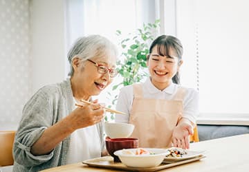 職員と談笑して食事をしている入居者